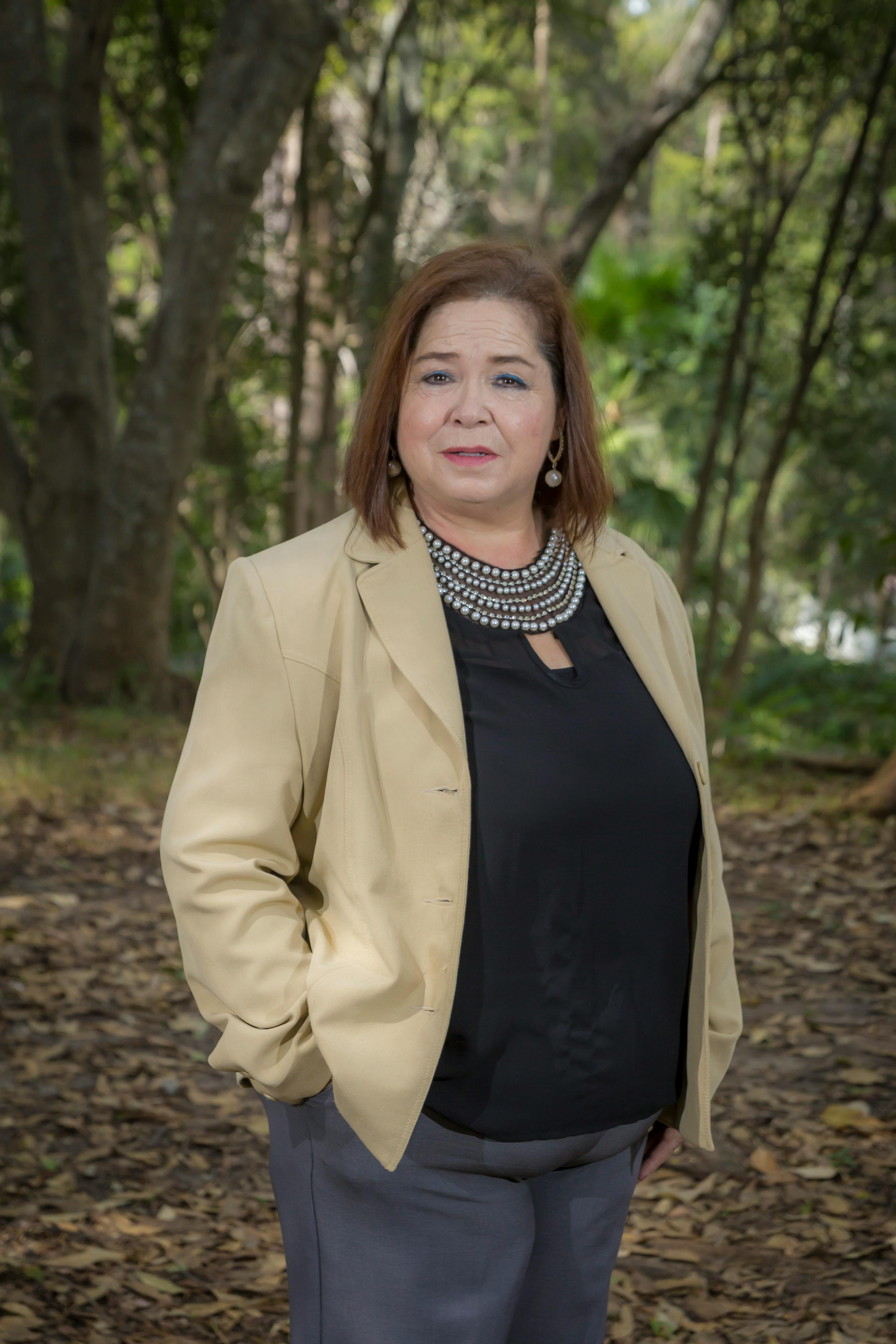 Confident woman in business attire standing outdoors, exuding professionalism.