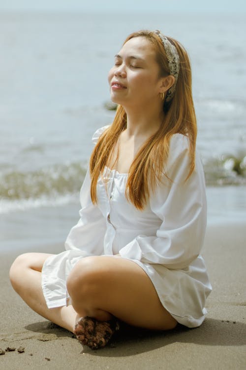 Young woman meditating on seashore