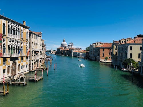 Buildings Beside Body of Water Under Blue Sky