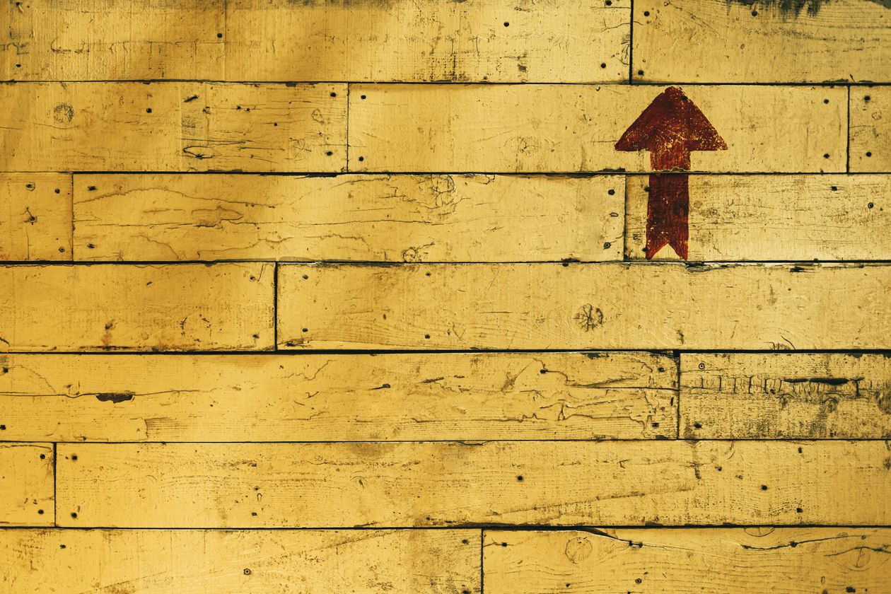 Red arrow painted on yellow wooden panels representing the direction of referral growth