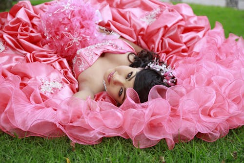 Woman in Pink Dress Lying on Green Grass