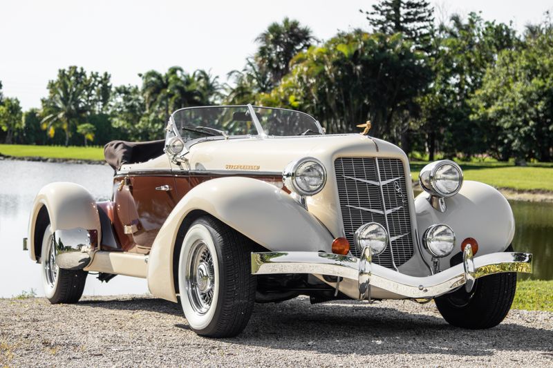 Classic open-top vintage car parked by scenic lake