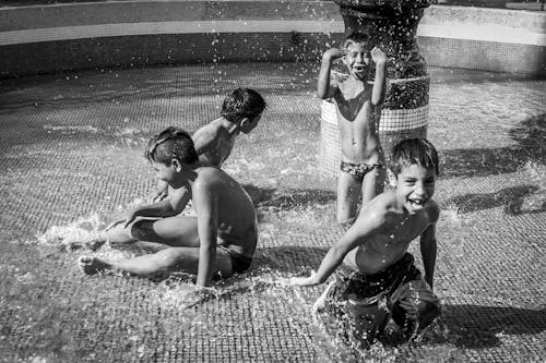 Grayscale Photo of Boys Having Fun Together 