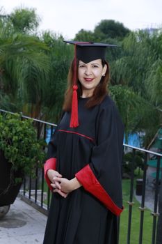 一位穿着学术服装的女性在户外拍摄毕业照