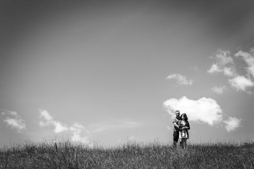 A Couple Standing on a Grass Field