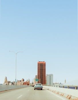 View of Buffalo, NY downtown skyline under a clear blue sky from a highway.