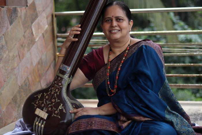 Smiling woman holding a tanpura