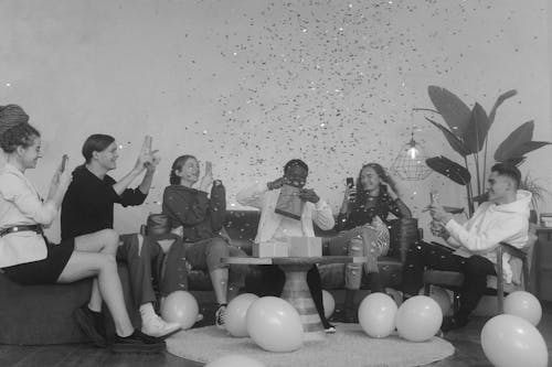 Grayscale Photo of People Sitting on Chairs