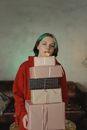 A Woman Carrying a Stack of Presents while Blowing a Whistle