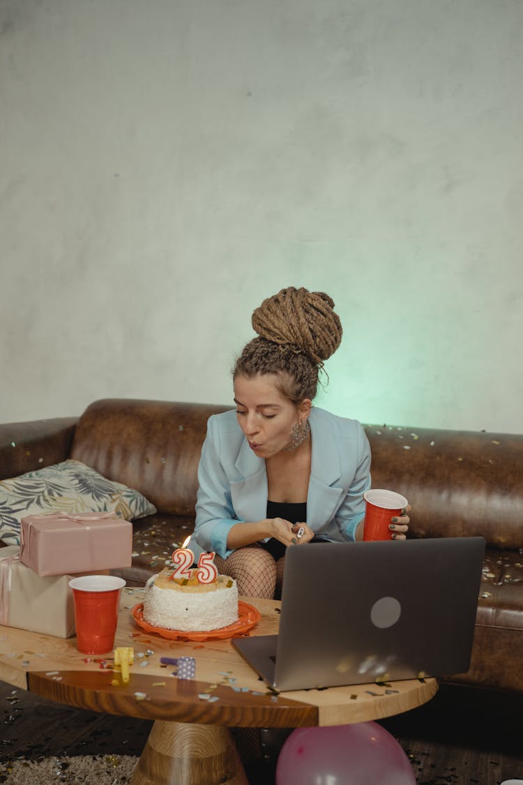 A Woman Blowing The Candles On Her Birthday Cake