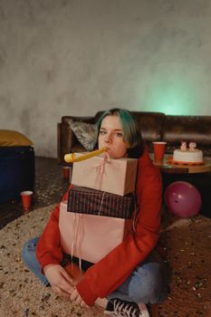 Young person with gifts and birthday decor in a festive indoor setting, highlighting celebration.