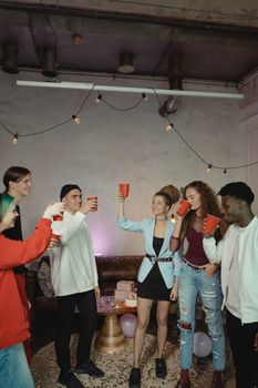 一群快乐的成年人在室内用红色杯子和节日气氛庆祝