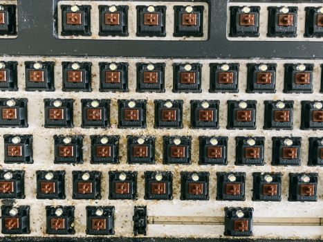 From above of keyboard panel without keycaps full of dust and dirt before cleaning