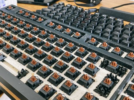From above of computer keyboard with removed keycaps for cleaning dust and dirt