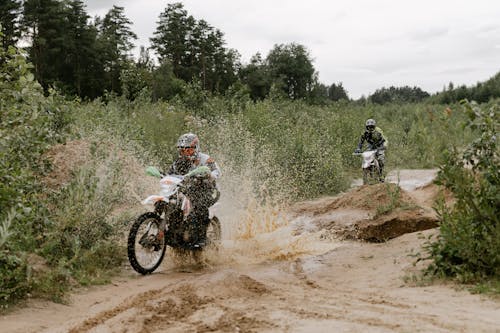 モトクロスダートバイクに乗る黒と白のジャケットの男