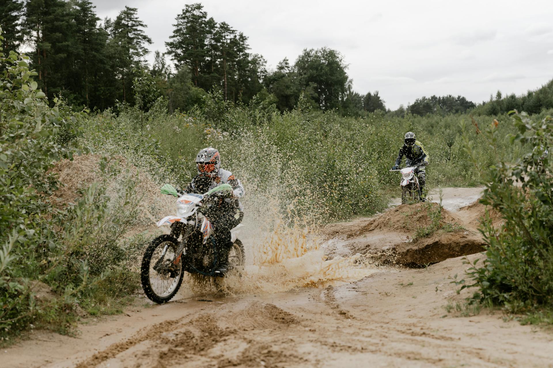 Two People riding Dirt Bike