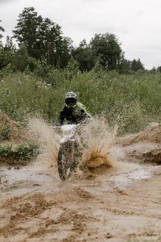 Thrilling dirt bike action as a rider navigates a muddy path, capturing the spirit of motocross sports.