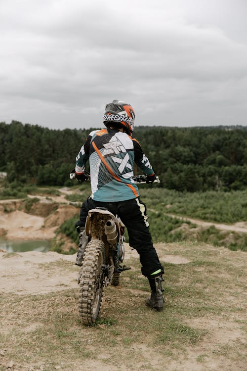 Kostenlos Mann In Der Schwarzen Und Orange Jacke, Die Auf Motocross Dirt Bike Reitet Stock-Foto