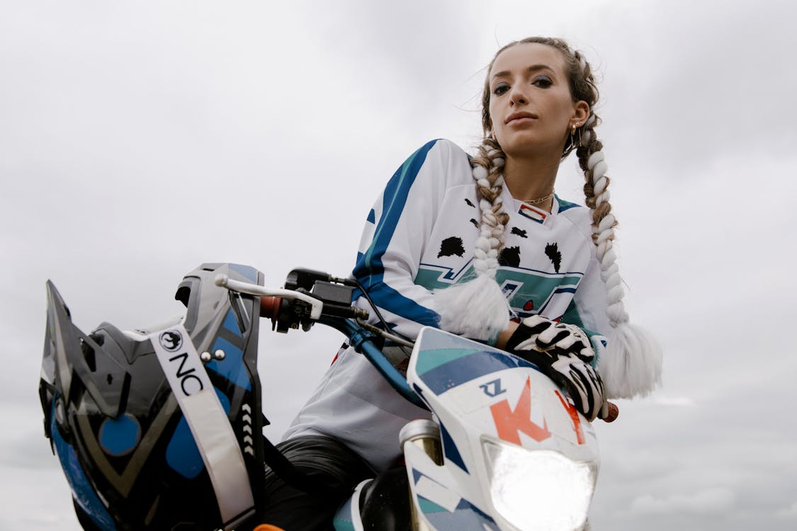 Free A Woman Posing while Sitting on a Dirt Bike Stock Photo