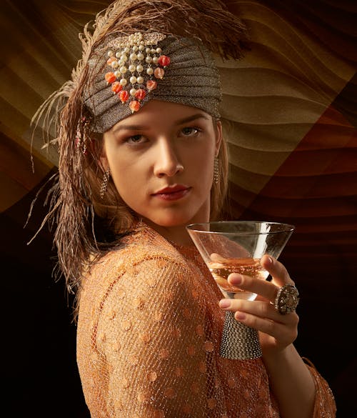 A Stylish Woman Wearing a Headdress Holding a Cocktail Drink