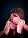 People covering face and mouth of helpless woman