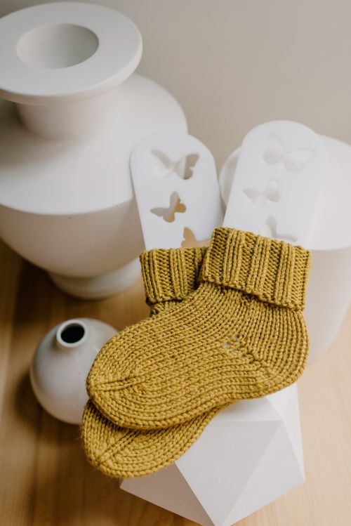 Knitted socks styled on a neutral surface — Ksenia Chernaya on Pexels