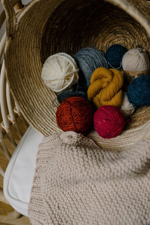 Free A collection of vibrant yarn balls in a rustic woven basket, perfect for knitting projects. Stock Photo