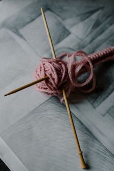 粉红色纱线在纹理背景上别着针，展现了工艺爱好