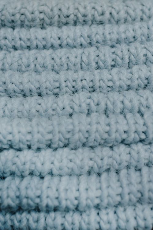 Free Detailed close-up of a white knitted fabric showcasing intricate texture and pattern. Stock Photo