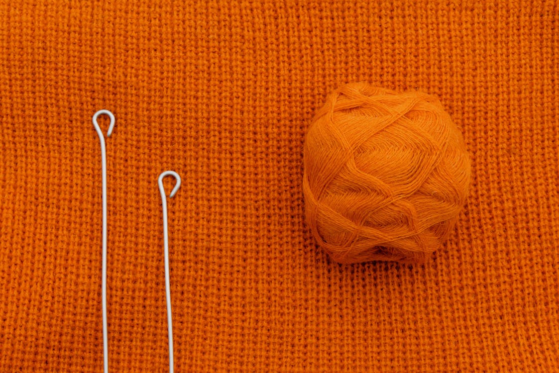Knitting Needles and an Orange Thread