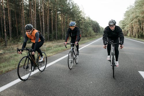 Three People Biking on the Road