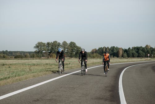 Free Three People Biking on the Road Stock Photo