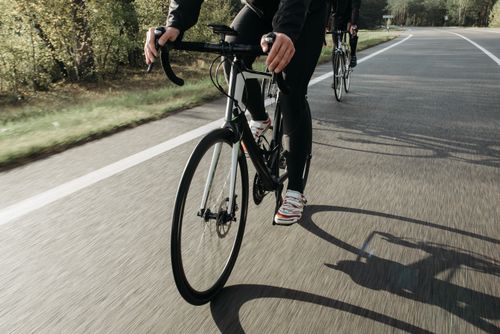 Free Close-up of cyclists racing on a sunny road, showcasing speed and determination. Stock Photo