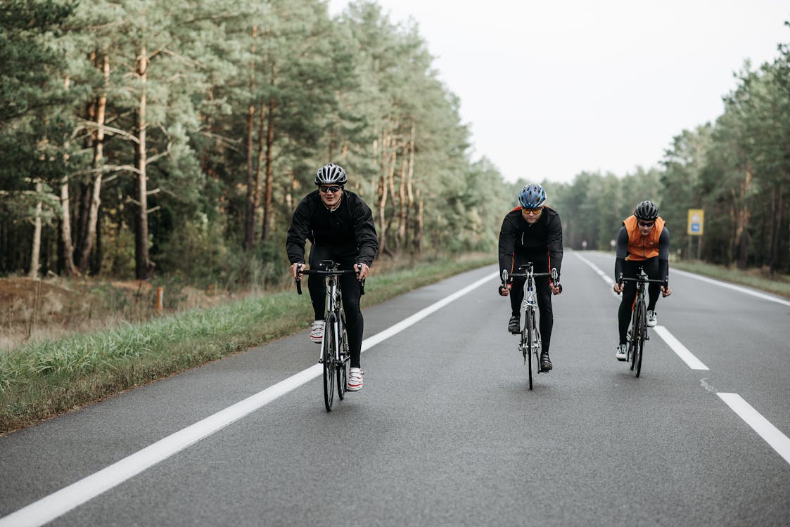 Free People Riding Bicycle on Road Stock Photo