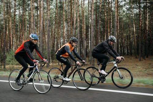 Free Men Riding Bicycles on the Road Stock Photo