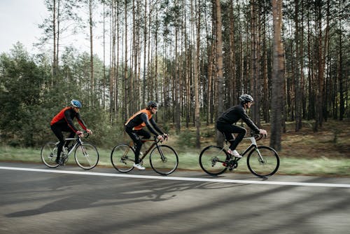 Free Men Riding on Bicycle on Roadside Stock Photo