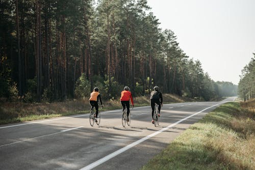 Free Men Riding Bicycles on the Road Stock Photo