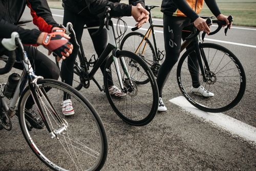 Free Group of cyclists with modern road bikes getting ready for a competitive ride on asphalt road. Stock Photo