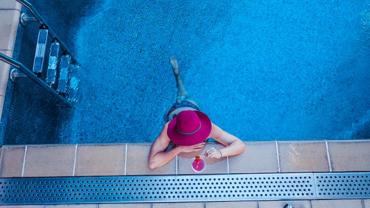 A Woman Having A Drink While In The Swimming Pool 