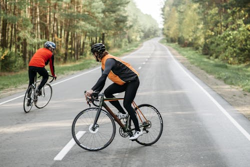 Two Men Riding on Bicycles on the Road