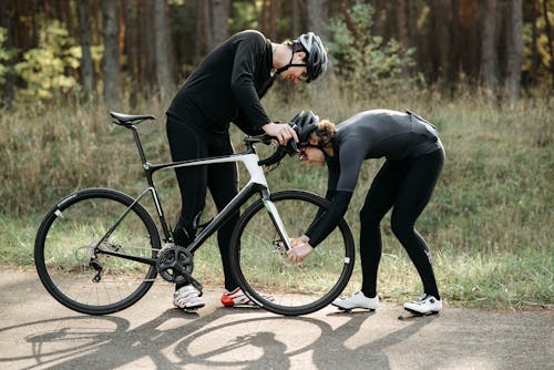 Two Cyclist Fixing Bicycle