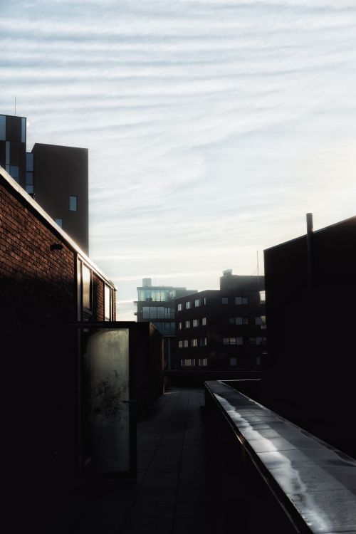 Free Silhouetted cityscape with modern buildings against evening sky. Stock Photo