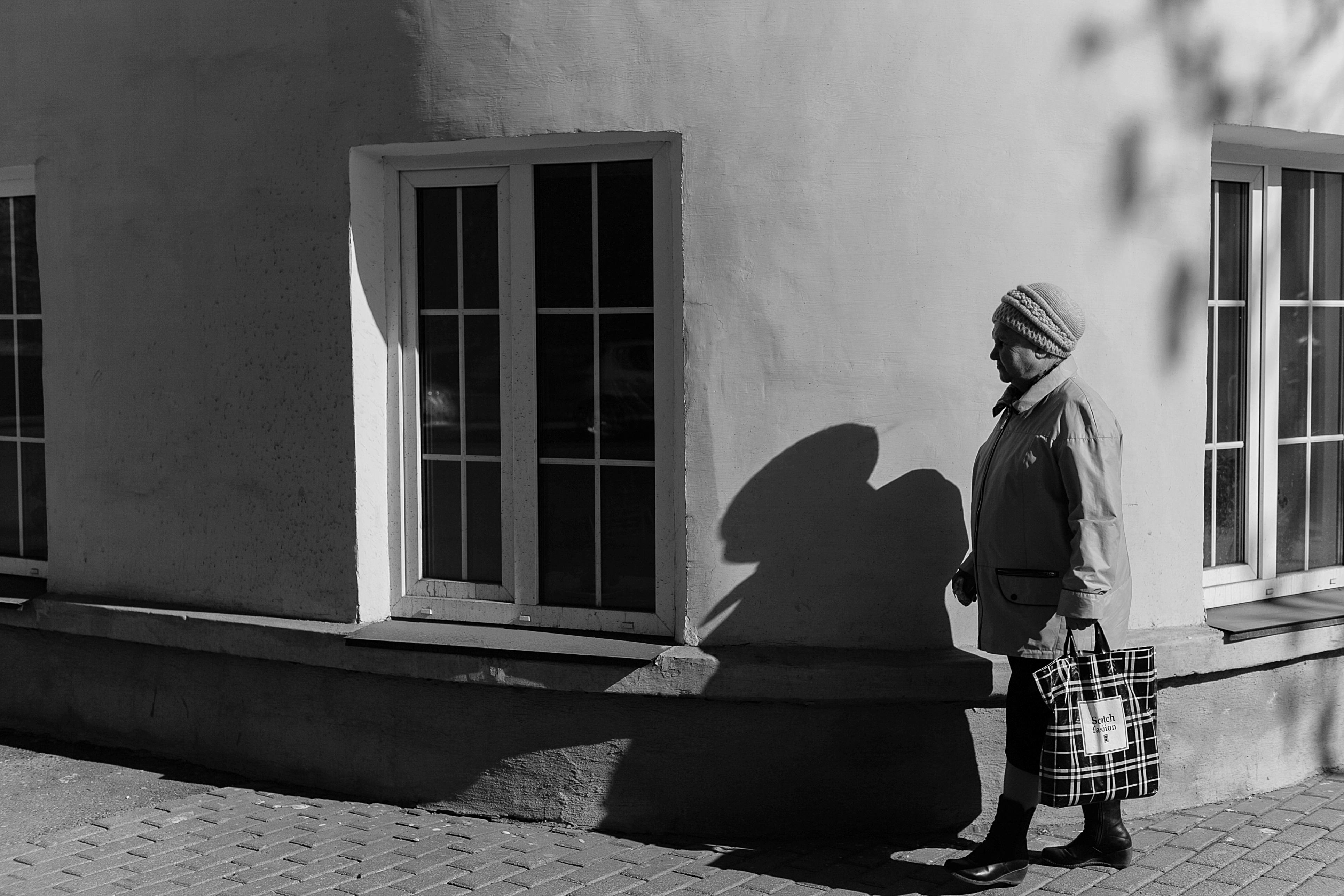 Old man walking near board with posters on street · Free Stock Photo