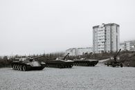 Black and white of monuments of various military vehicles on square in city