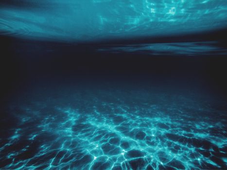 Deep blue underwater scene with captivating light and shadow play.
