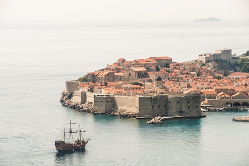 Brown Sailing Ship Near Building