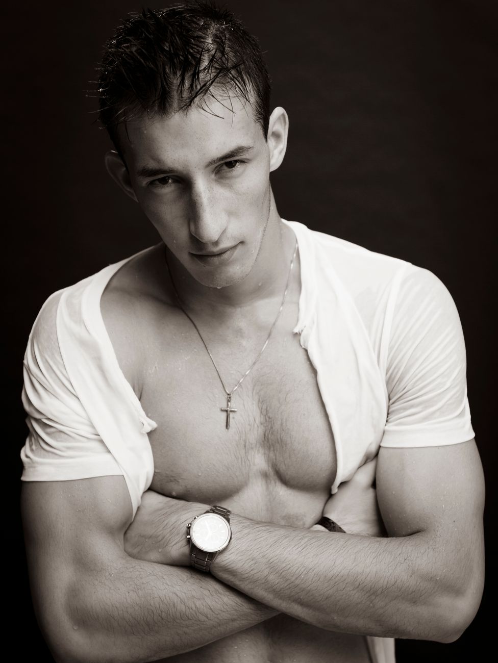 Monochrome portrait of a muscular man with wet hair and a necklace, exuding confidence.