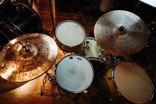 Overhead shot of a drum set with cymbals in a cozy music studio.