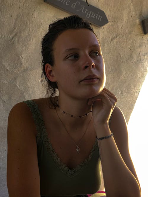 A Woman in Green Tank Top Wearing a Silver Necklace