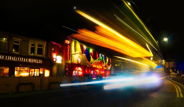 Dynamic city scene at night with vibrant neon and light trails along a bustling street.